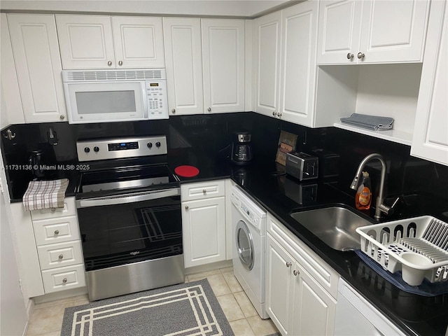 kitchen featuring light tile patterned flooring, washer / dryer, white cabinetry, electric range, and backsplash