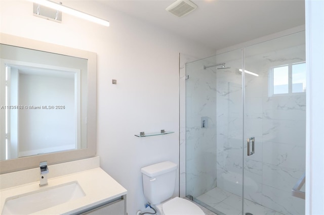 bathroom featuring vanity, toilet, and a shower with shower door