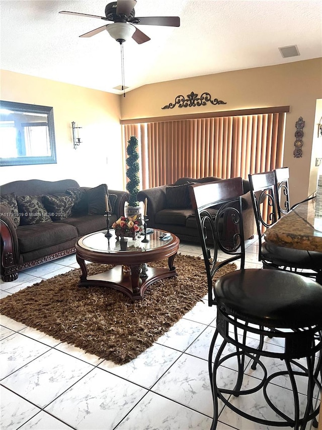 living room with a healthy amount of sunlight, ceiling fan, and a textured ceiling