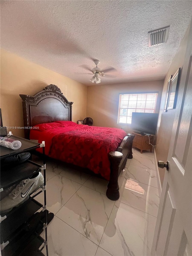 bedroom with a textured ceiling and ceiling fan