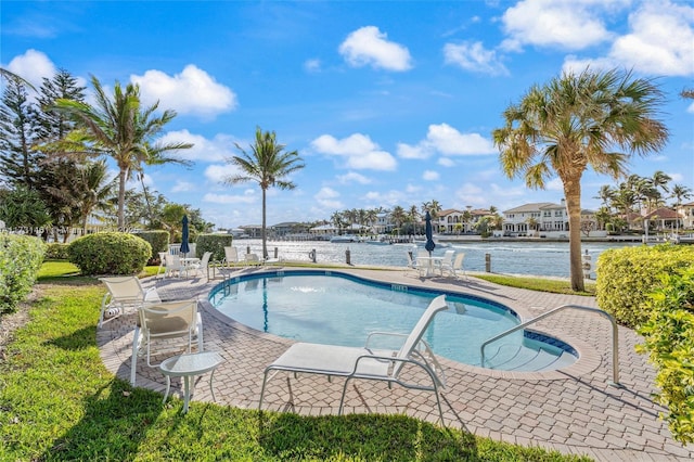 view of pool featuring a patio and a water view