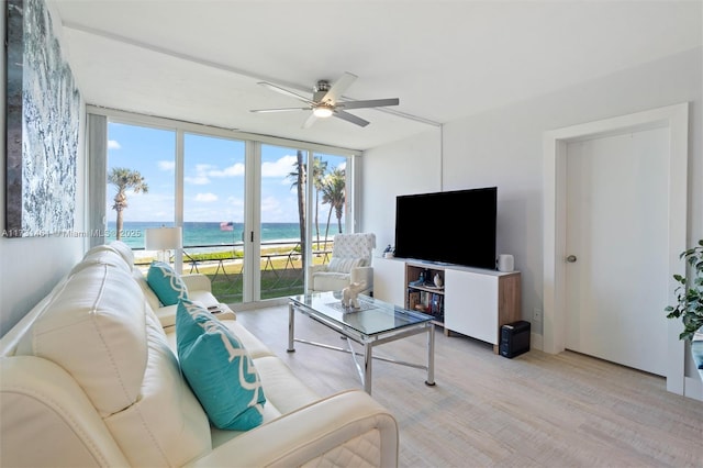 living room featuring floor to ceiling windows, ceiling fan, and light hardwood / wood-style flooring