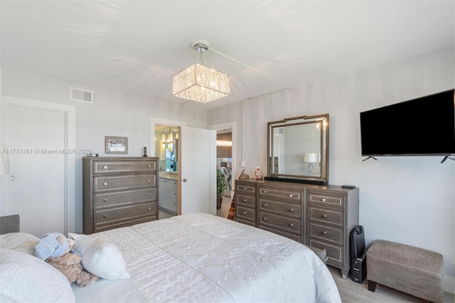 bedroom with a notable chandelier and ensuite bathroom