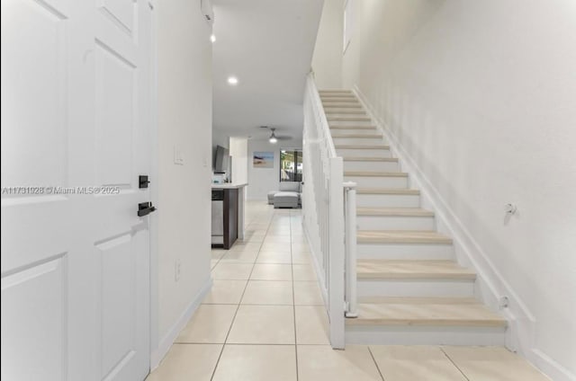 stairs with tile patterned floors and ceiling fan