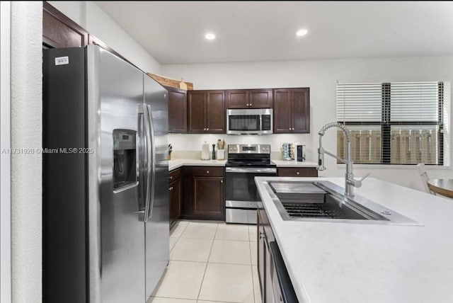 kitchen featuring appliances with stainless steel finishes, sink, and light tile patterned floors