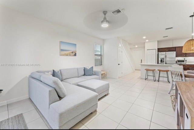 tiled living room with ceiling fan