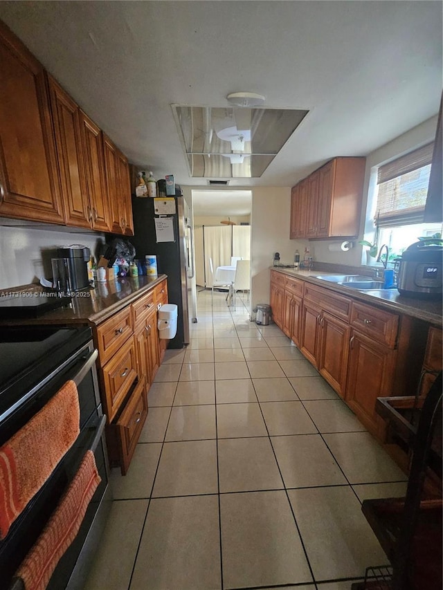 kitchen featuring appliances with stainless steel finishes, sink, and light tile patterned floors