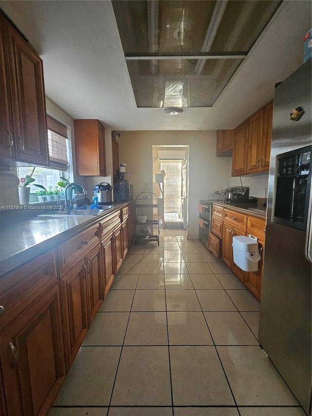 kitchen with sink, stainless steel fridge, and light tile patterned flooring