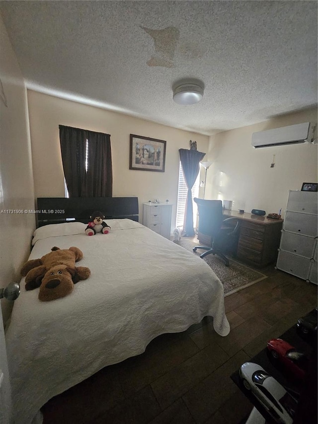 bedroom with hardwood / wood-style floors, a textured ceiling, and a wall mounted AC