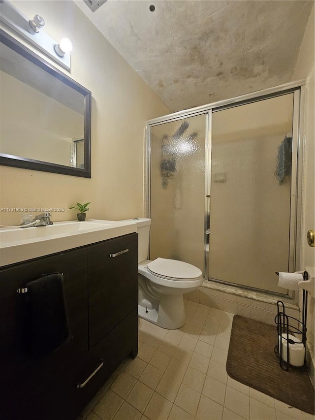 bathroom featuring tile patterned flooring, vanity, a shower with door, and toilet