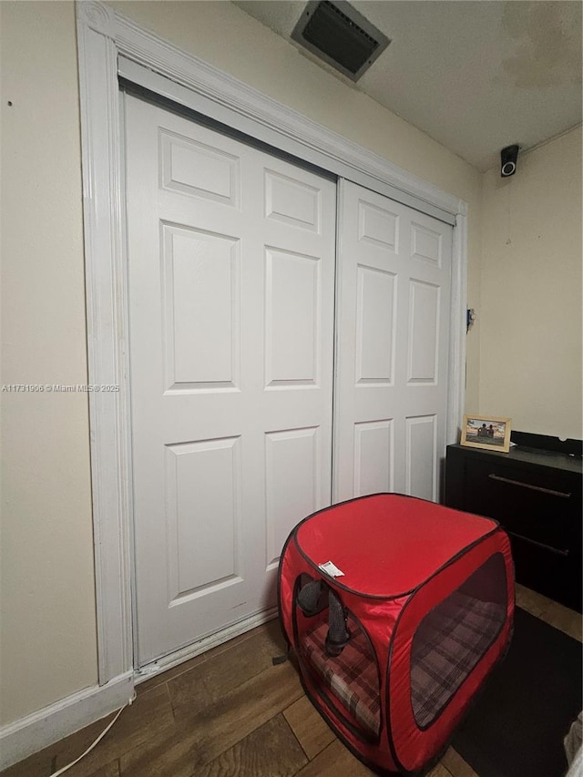 bedroom featuring dark wood-type flooring and a closet