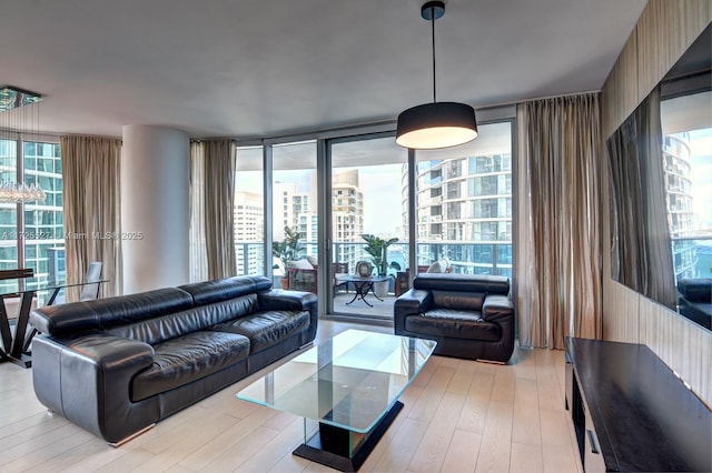 living room featuring a wall of windows and light wood-type flooring