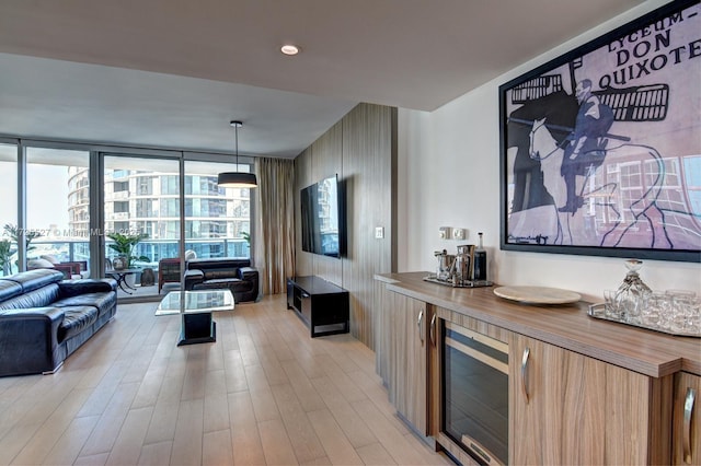 kitchen featuring light hardwood / wood-style flooring, butcher block counters, floor to ceiling windows, wine cooler, and decorative light fixtures