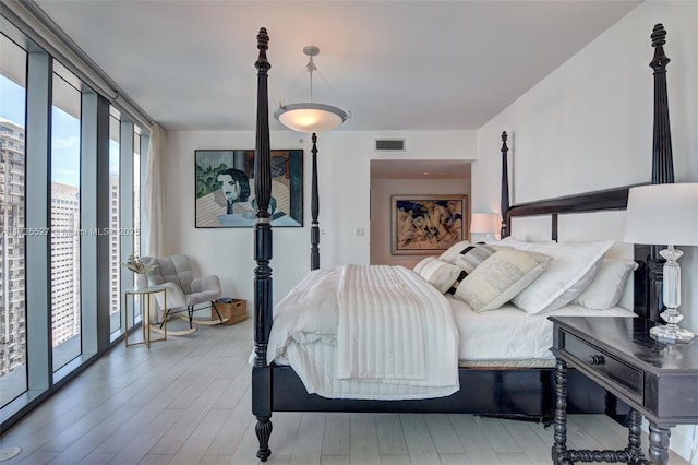 bedroom with hardwood / wood-style flooring, access to exterior, and multiple windows