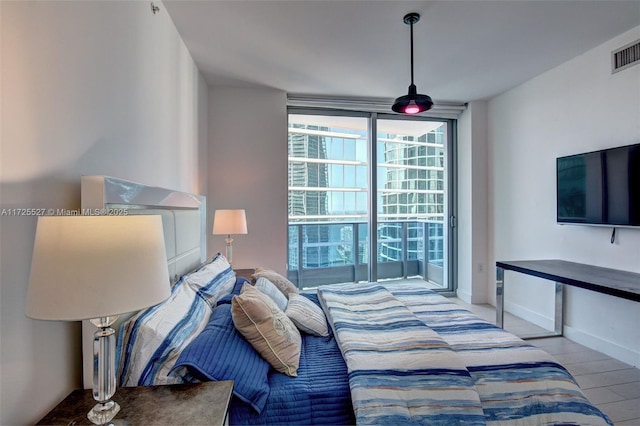 bedroom featuring expansive windows and light hardwood / wood-style flooring