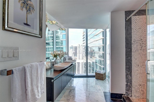 bathroom featuring sink, a shower with shower door, and floor to ceiling windows