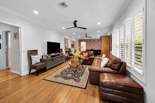 living room featuring crown molding, ceiling fan, and light wood-type flooring