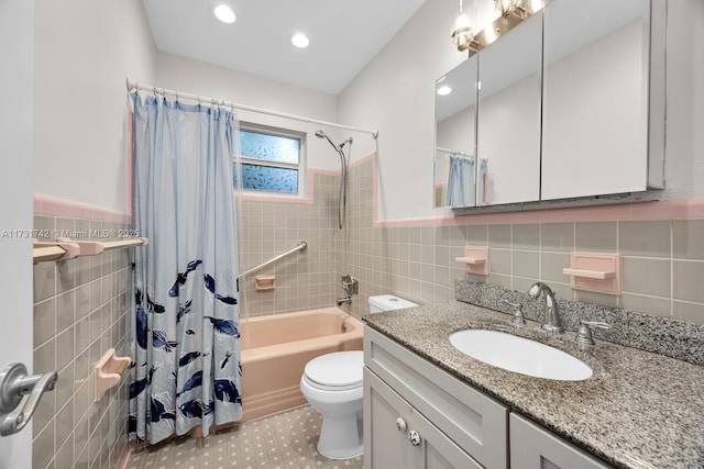 full bathroom with shower / bath combo, tile walls, vanity, and toilet