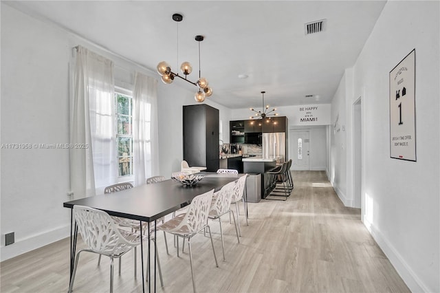 dining space with a chandelier and light wood-type flooring