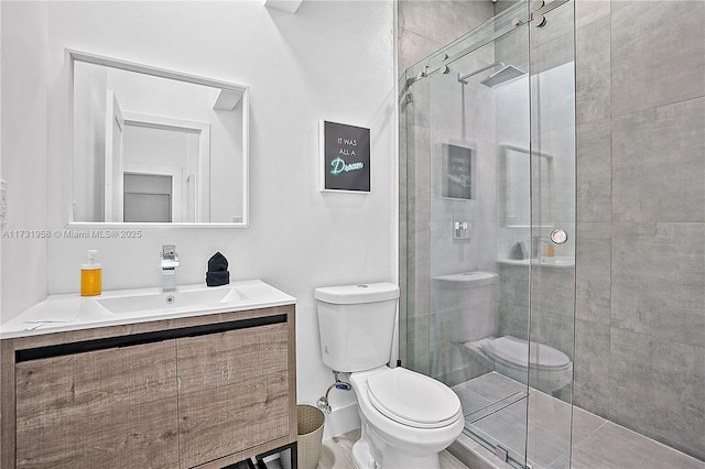 bathroom featuring vanity, a shower with door, and toilet