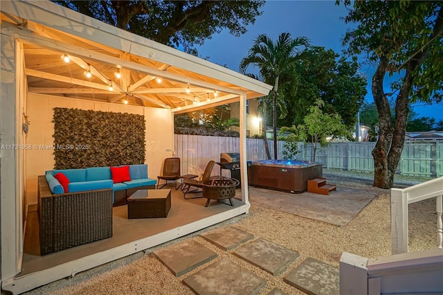 view of patio featuring a hot tub and an outdoor living space with a fire pit