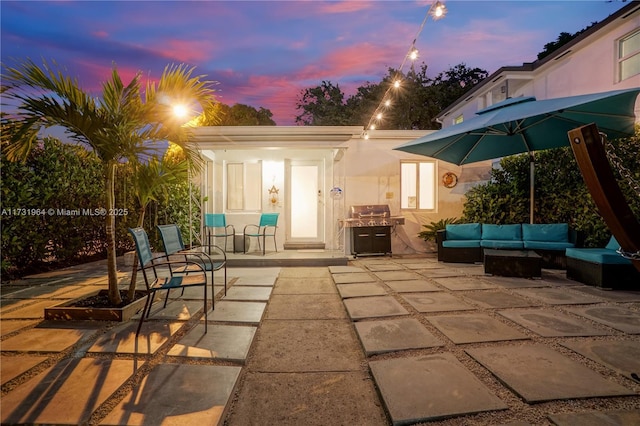 patio terrace at dusk featuring outdoor lounge area and grilling area