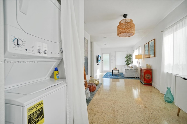 washroom with stacked washer and dryer and plenty of natural light