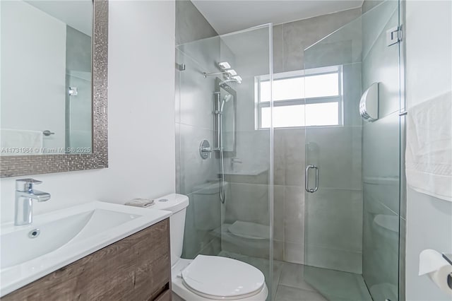 bathroom with vanity, toilet, and a shower with door