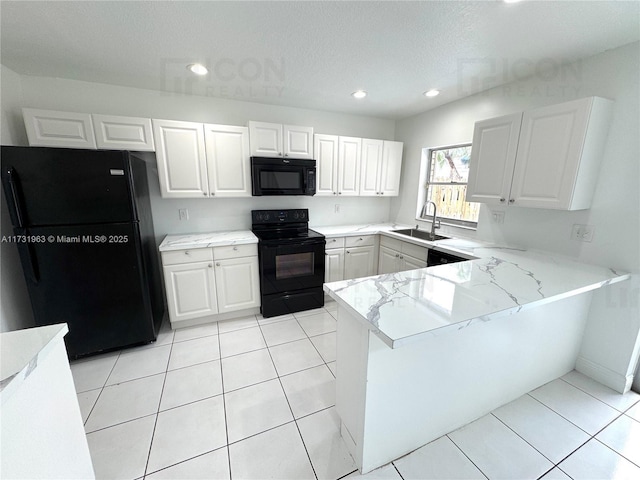 kitchen featuring black appliances, white cabinetry, sink, light tile patterned floors, and kitchen peninsula