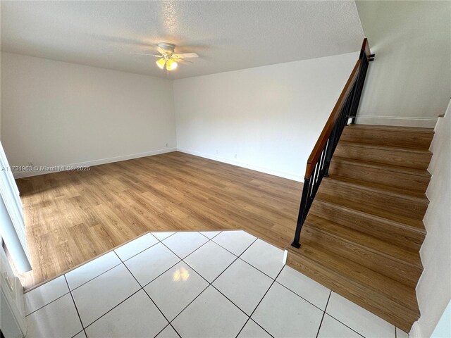 8212 SW 23rd Ct Unit 18D, North Lauderdale, FL 33068 - unfurnished room with stairs, wood finished floors, a ceiling fan, baseboards, and a textured ceiling