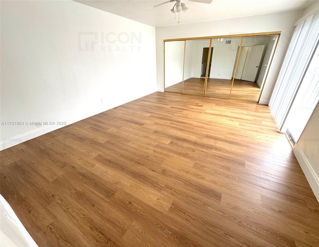 unfurnished bedroom featuring ceiling fan, light hardwood / wood-style floors, and a closet