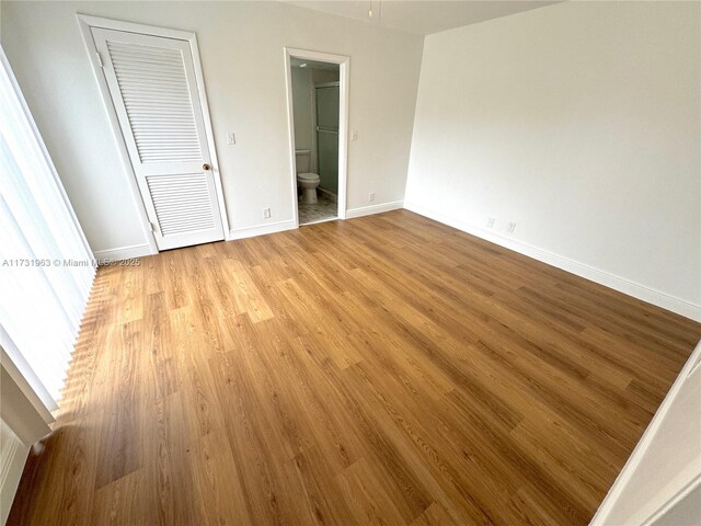 8212 SW 23rd Ct Unit 18D, North Lauderdale, FL 33068 - unfurnished bedroom with light wood finished floors, baseboards, and connected bathroom