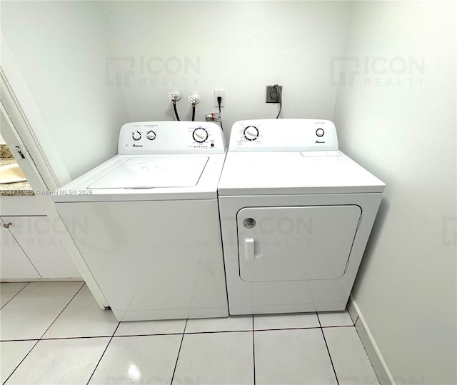 clothes washing area with washer and dryer and light tile patterned floors