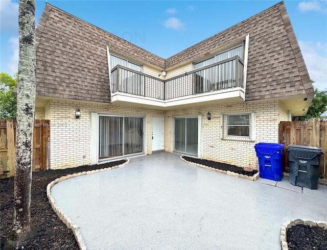 rear view of house with a patio and a balcony