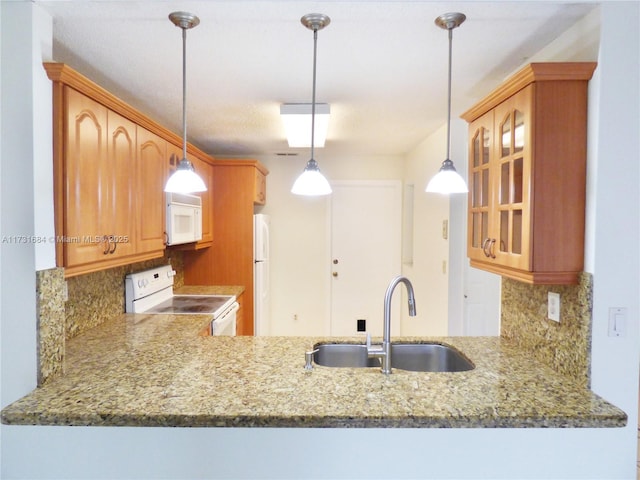 kitchen with tasteful backsplash, sink, white appliances, and decorative light fixtures