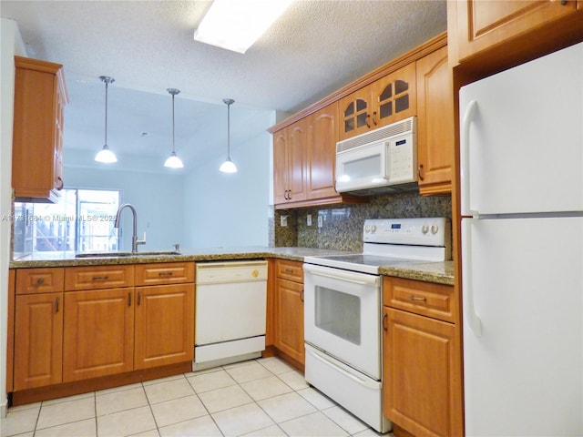 kitchen with decorative light fixtures, tasteful backsplash, sink, light stone counters, and white appliances