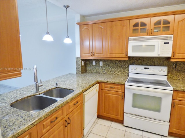 kitchen featuring sink, white appliances, tasteful backsplash, light stone counters, and decorative light fixtures