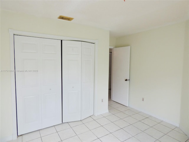 unfurnished bedroom featuring light tile patterned floors and a closet