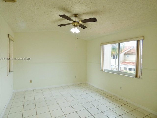 spare room with light tile patterned flooring, lofted ceiling, ceiling fan, and a textured ceiling