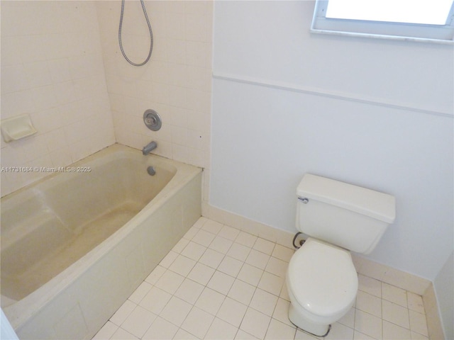 bathroom with tiled shower / bath combo, tile patterned floors, and toilet