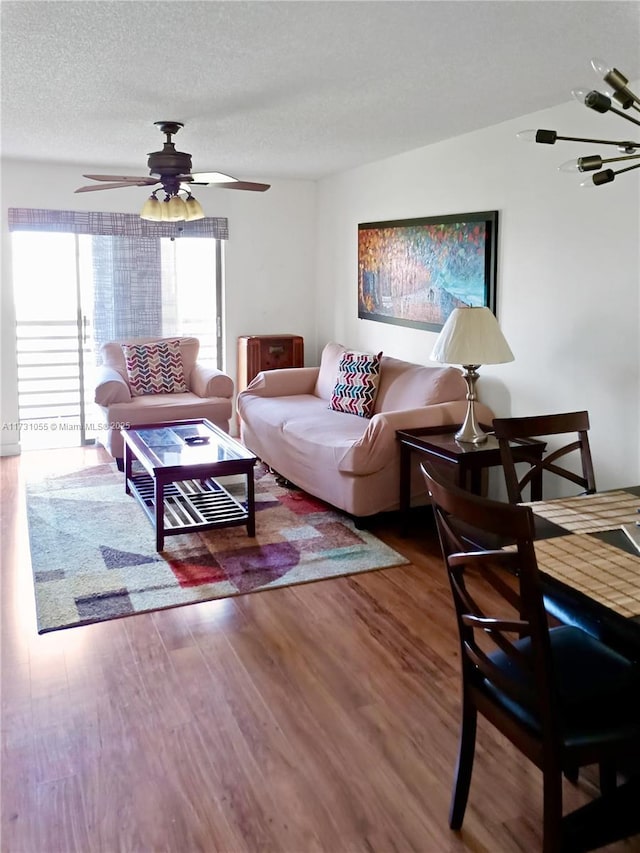 living room with ceiling fan, hardwood / wood-style floors, and a textured ceiling