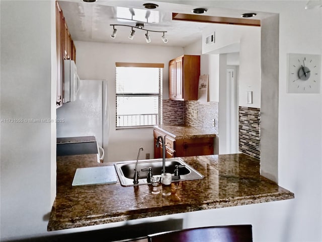 kitchen featuring sink, backsplash, and range