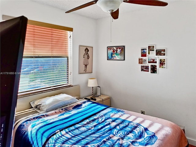 bedroom with multiple windows, a textured ceiling, and ceiling fan