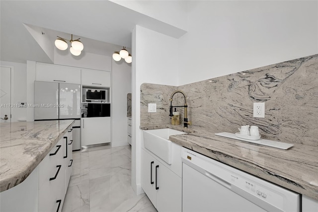 kitchen featuring tasteful backsplash, white cabinetry, light stone countertops, and white appliances