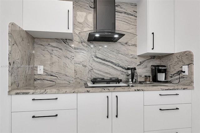 kitchen featuring white cabinetry, light stone countertops, ventilation hood, and decorative backsplash