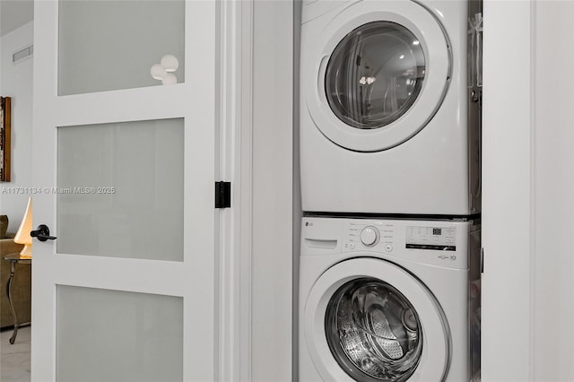 clothes washing area featuring stacked washer / drying machine