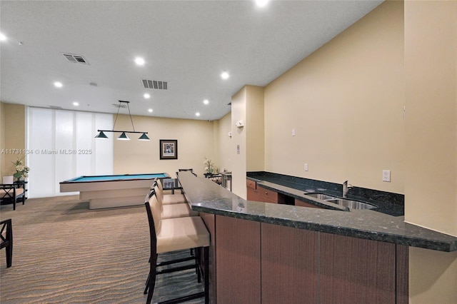 bar featuring sink, pool table, light carpet, pendant lighting, and dark stone counters