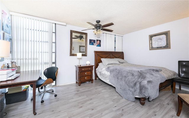 bedroom featuring ceiling fan, light hardwood / wood-style flooring, and a textured ceiling