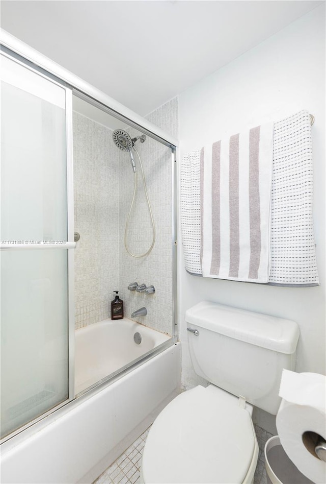 bathroom featuring combined bath / shower with glass door and toilet