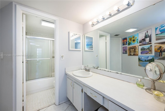 full bathroom featuring vanity, tile patterned floors, shower / bath combination with glass door, and toilet